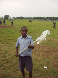 Kenyan student holding lacrosse stick donated by Charlie Lockwood of Gait/DeBeers Lacrosse